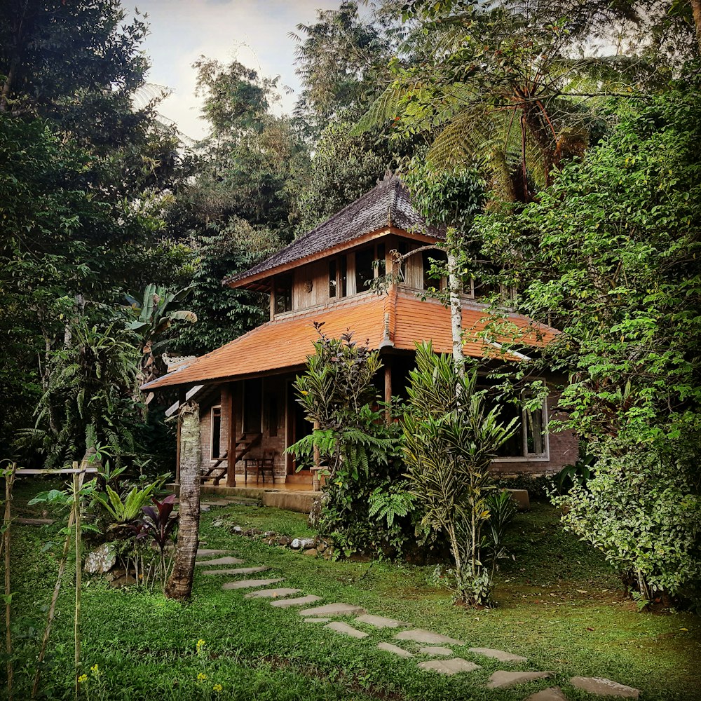 a wooden house surrounded by lush green trees