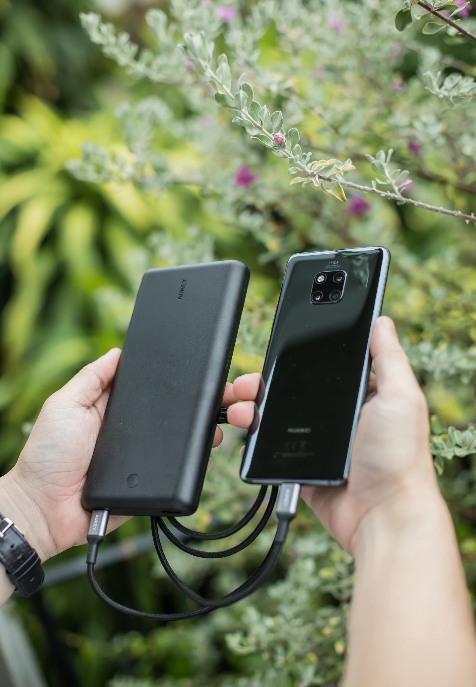 Smartphone connected to a portable power bank outdoors