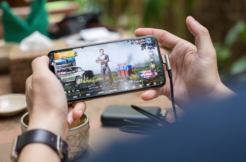 Free Photo  Happy beautiful girl playing mobile video game, holding  smartphone horizontally, watching on cellphone with excited face, pink  background.