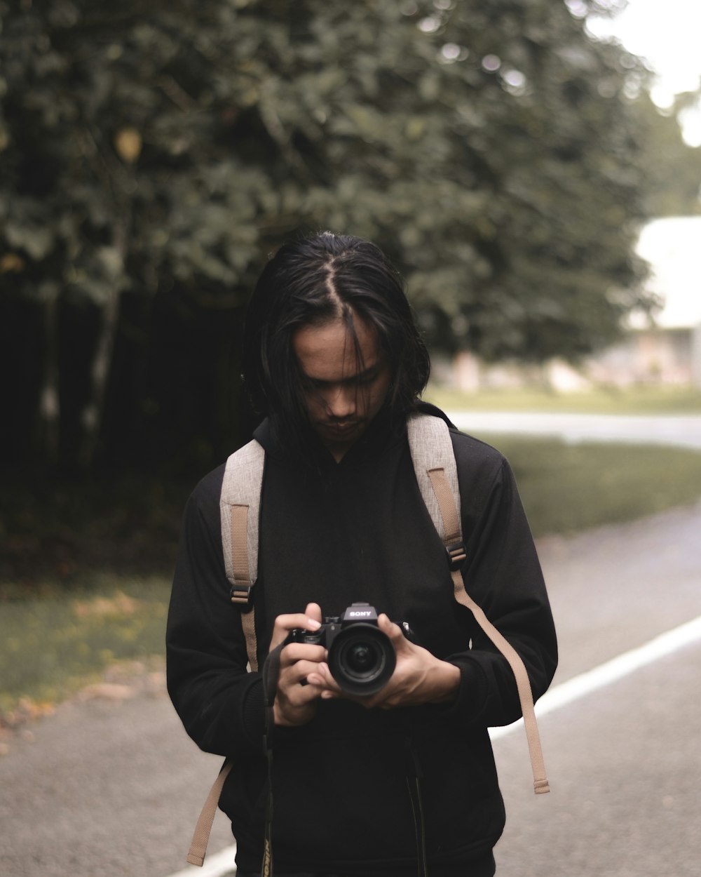 man in black hoodie holding camera