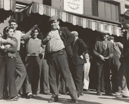 A group of union members chatting and laughing together outside a workplace.