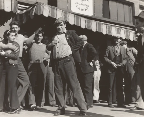 A group of union members chatting and laughing together outside a workplace.