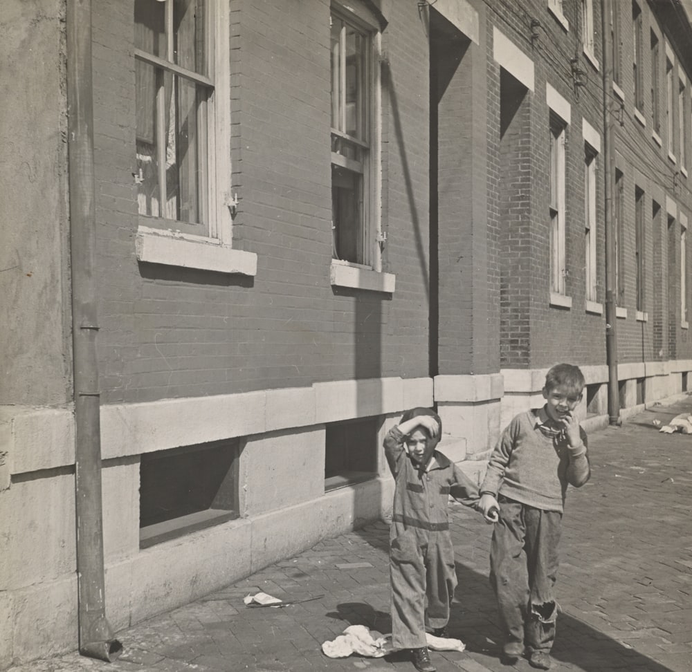 grayscale photography two toddlers standing outdoors