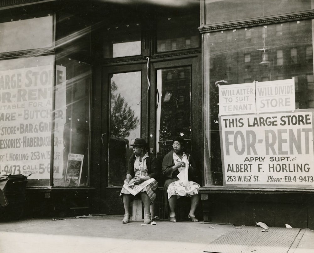 grayscale photography of two women sitting