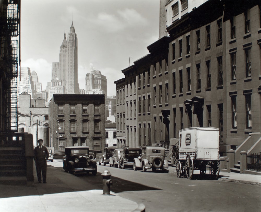 greyscale photo of vehicles beside buildings