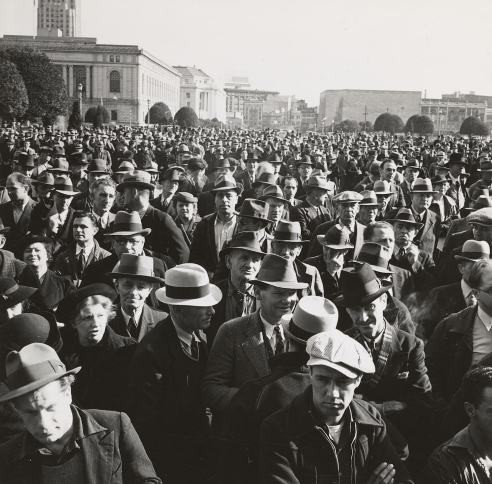 grayscale photo of people standing near buildings