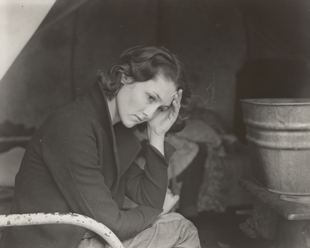 grayscale photography of woman sitting