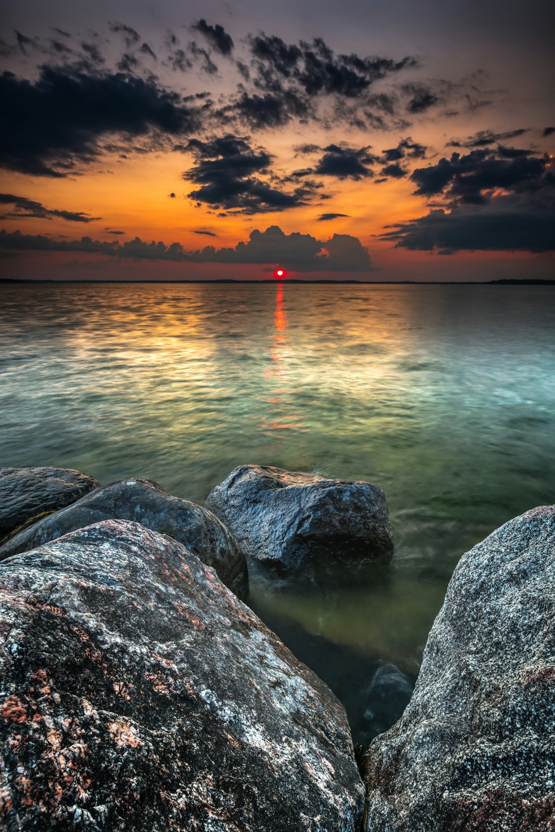 big gray rocks near seashore during sunset