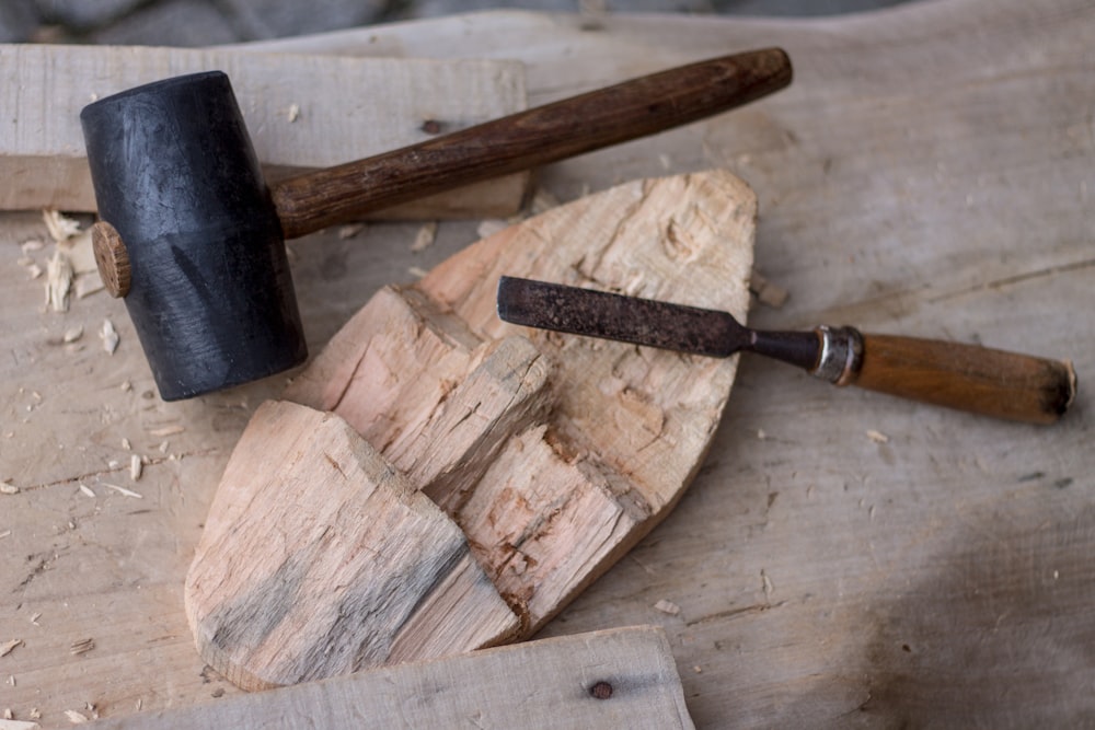 chisel near hammer on wooden board