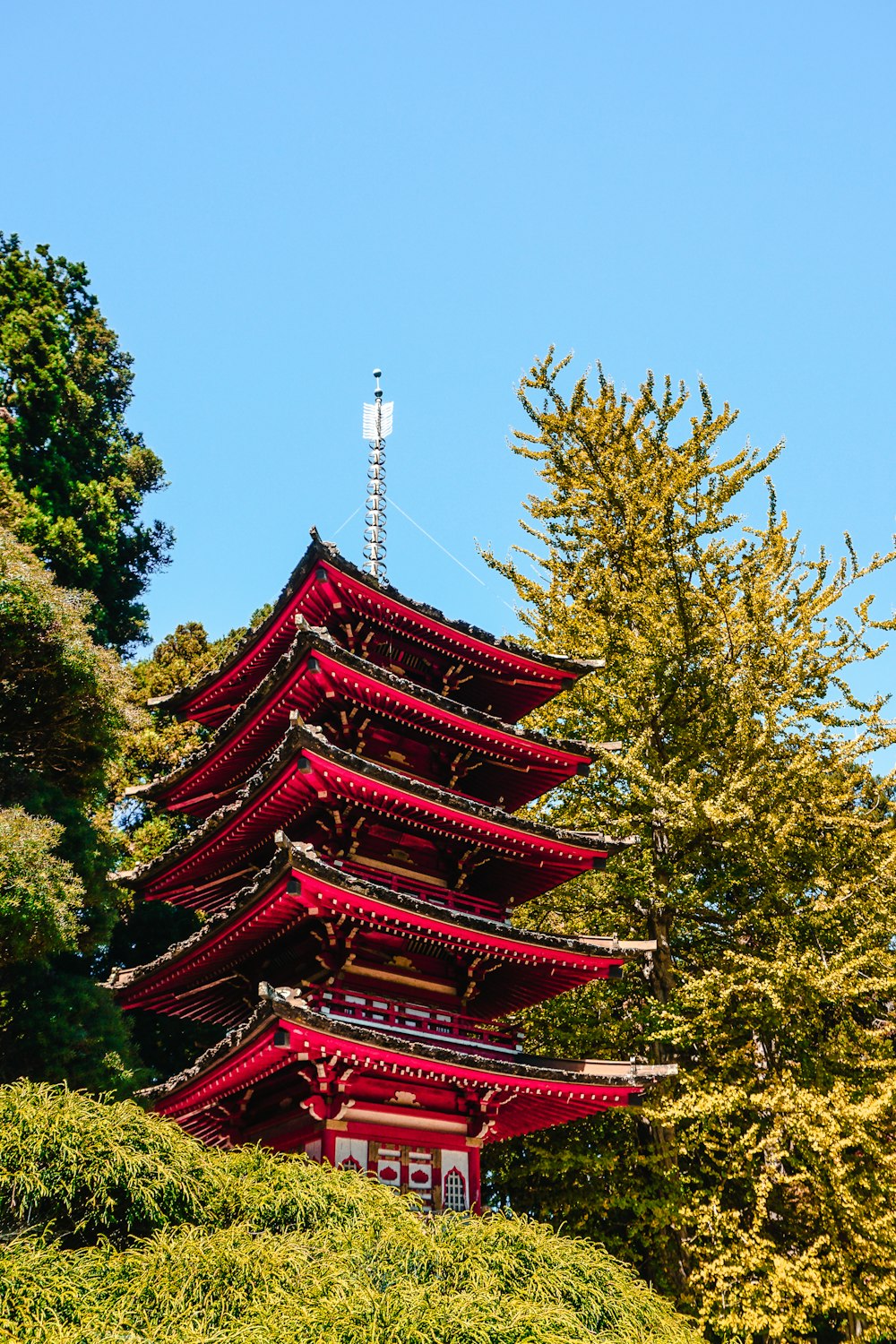 Tempio a pagoda multistrato rosso e verde sotto il cielo blu calmo