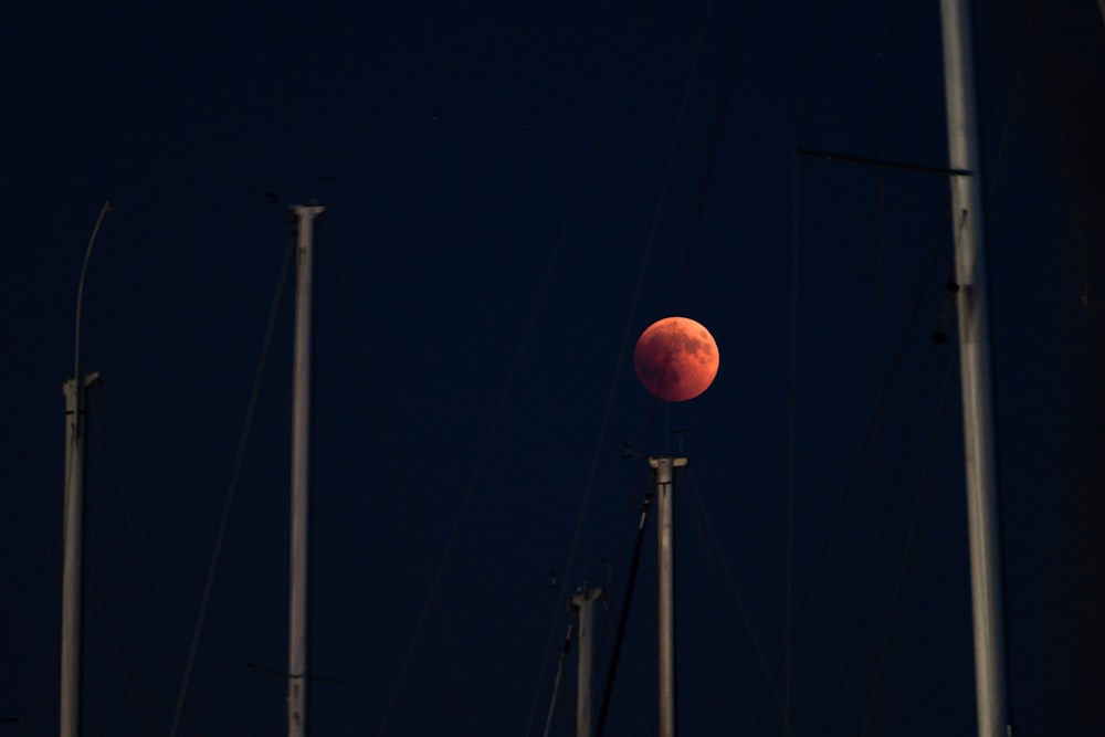 postes de hormigón blanco que muestran la luna llena por la noche