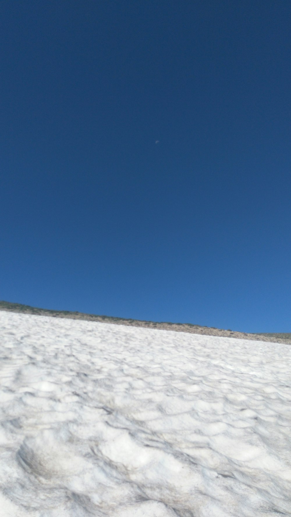 a snowboarder is going down a snowy hill