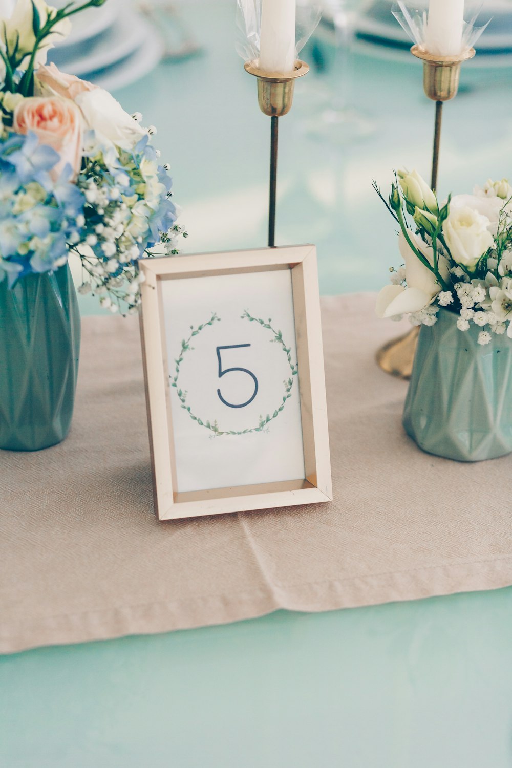 gold photo framed in middle of flower vases