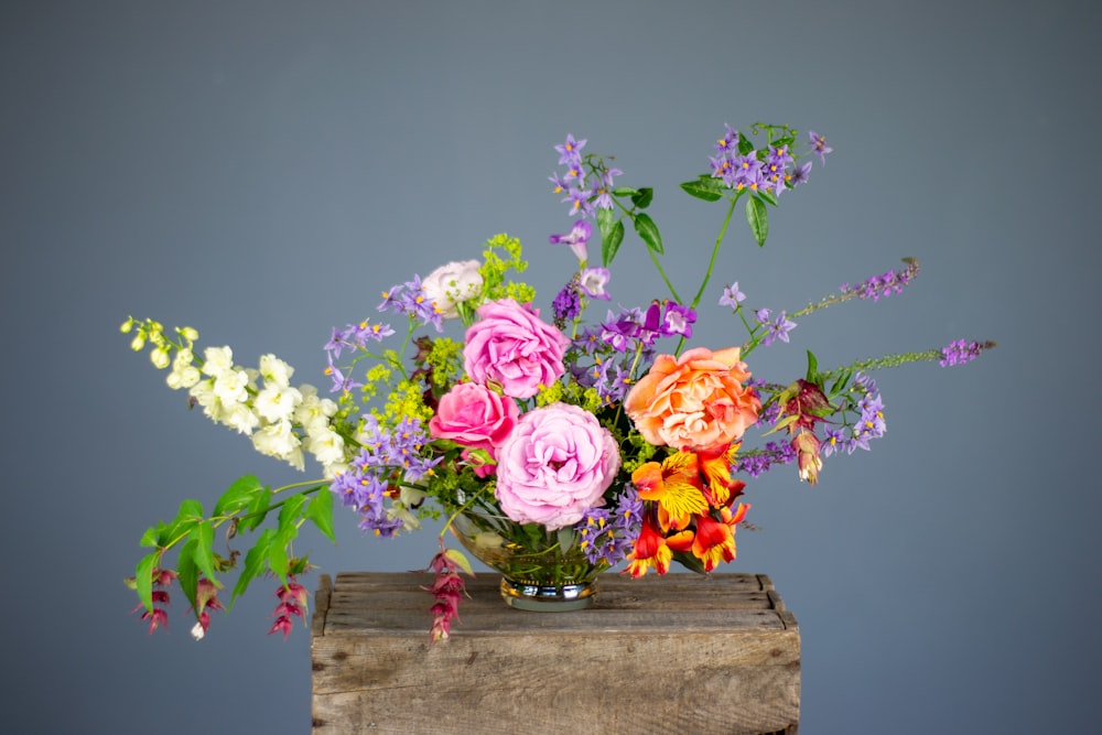 flores multicoloridas no vaso na superfície de madeira