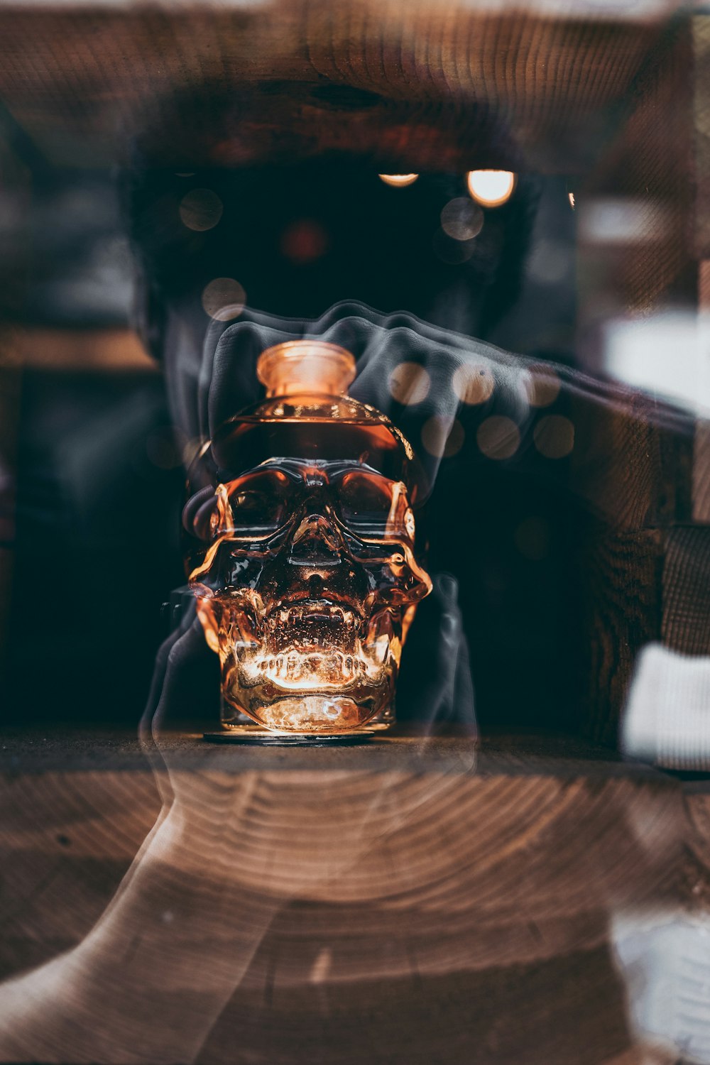 gold skull bottle behind glass panel