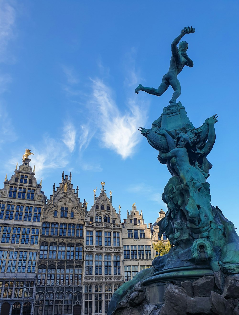 a statue in front of a building with a sky background