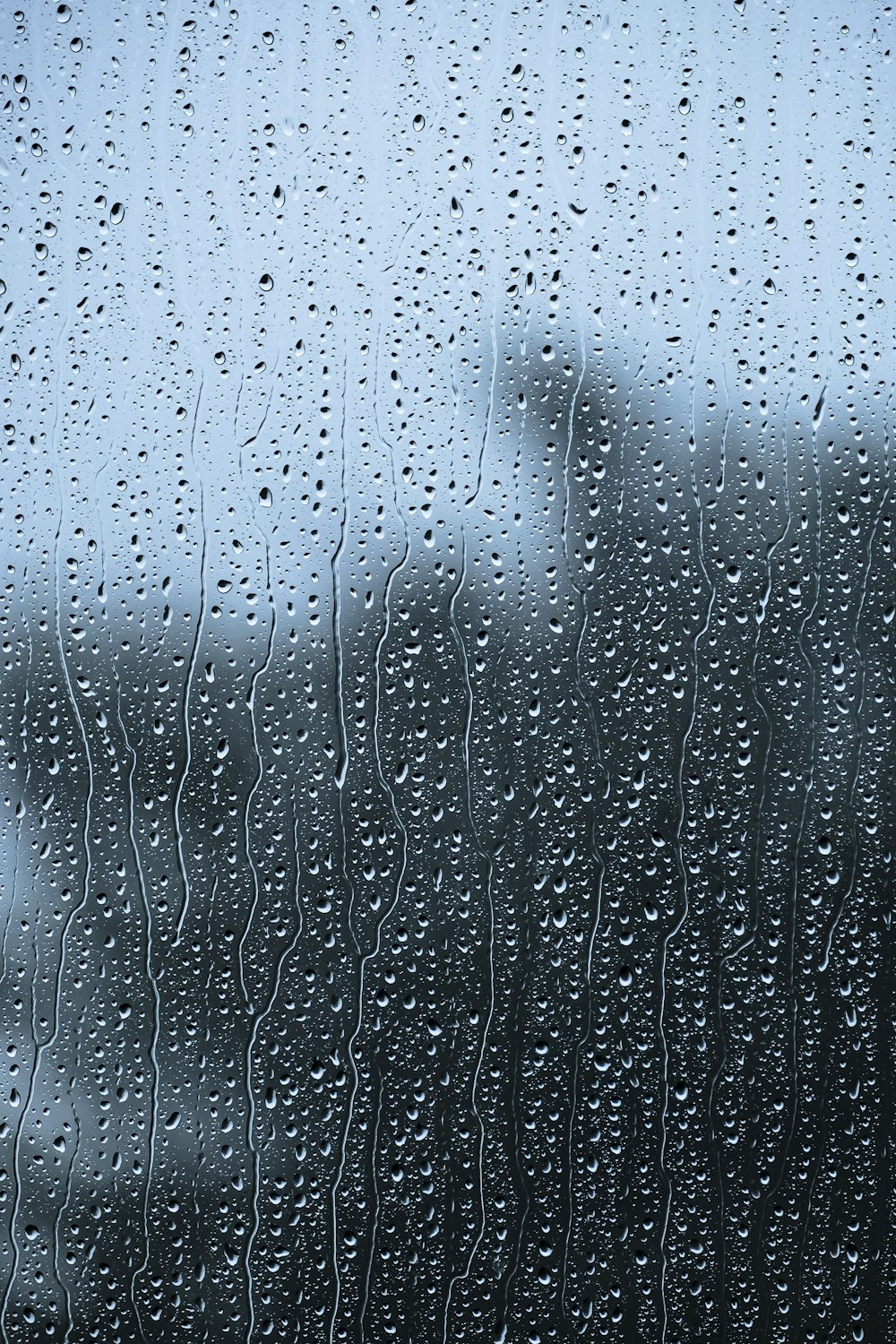 rain drops on a window with a building in the background