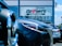 Several cars are parked in front of a dealership with a large window displaying the words 'Buy happy' and 'Brown's Fairfax Mazda'. The focus is on the cars in the foreground, while the dealership building is partially visible in the background.