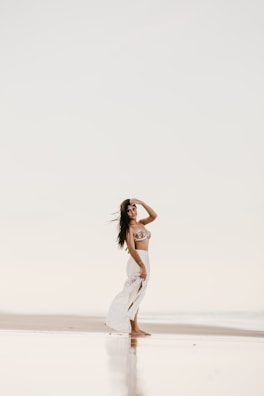 A serene setting featuring a woman in a flowy top by the beach.