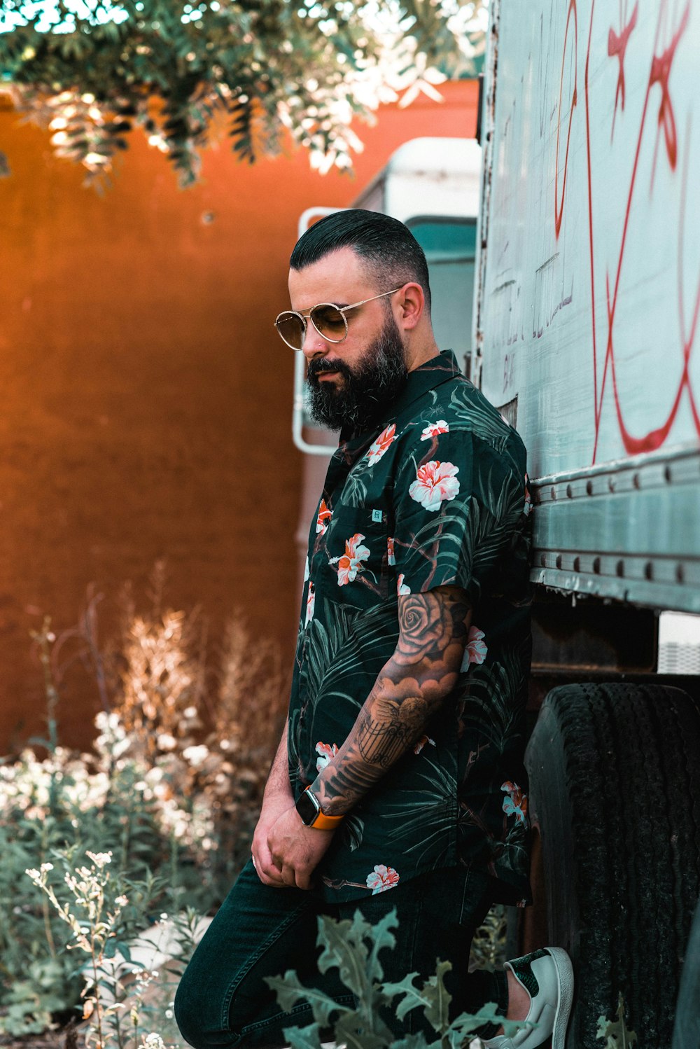 shallow focus photo of man in black and pink floral button-up T-shirt