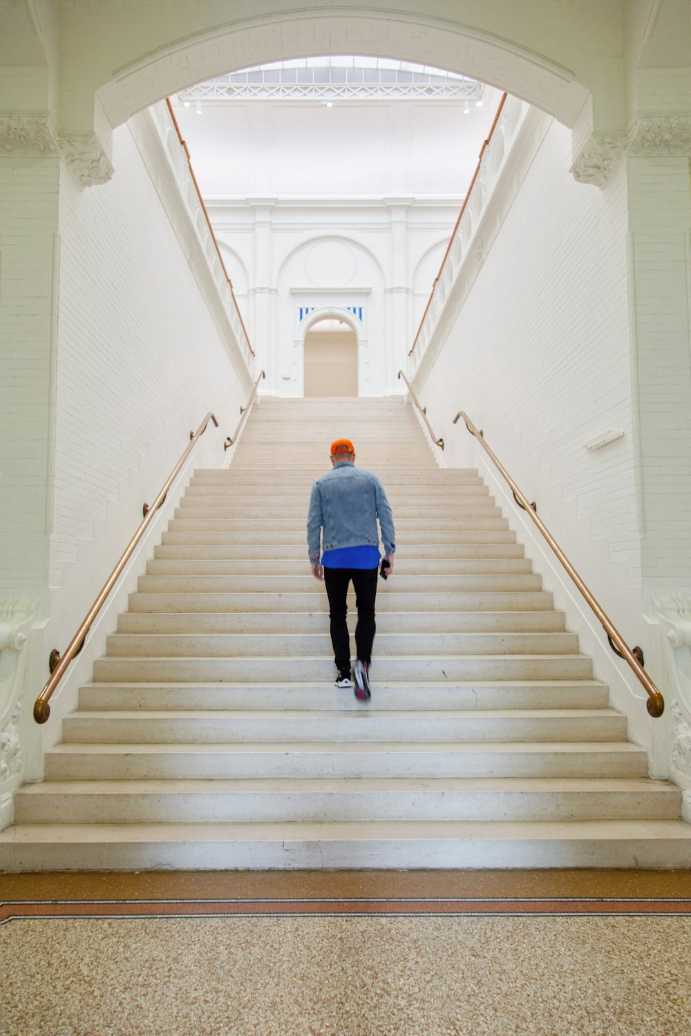 person in blue jacket walking at the stairs