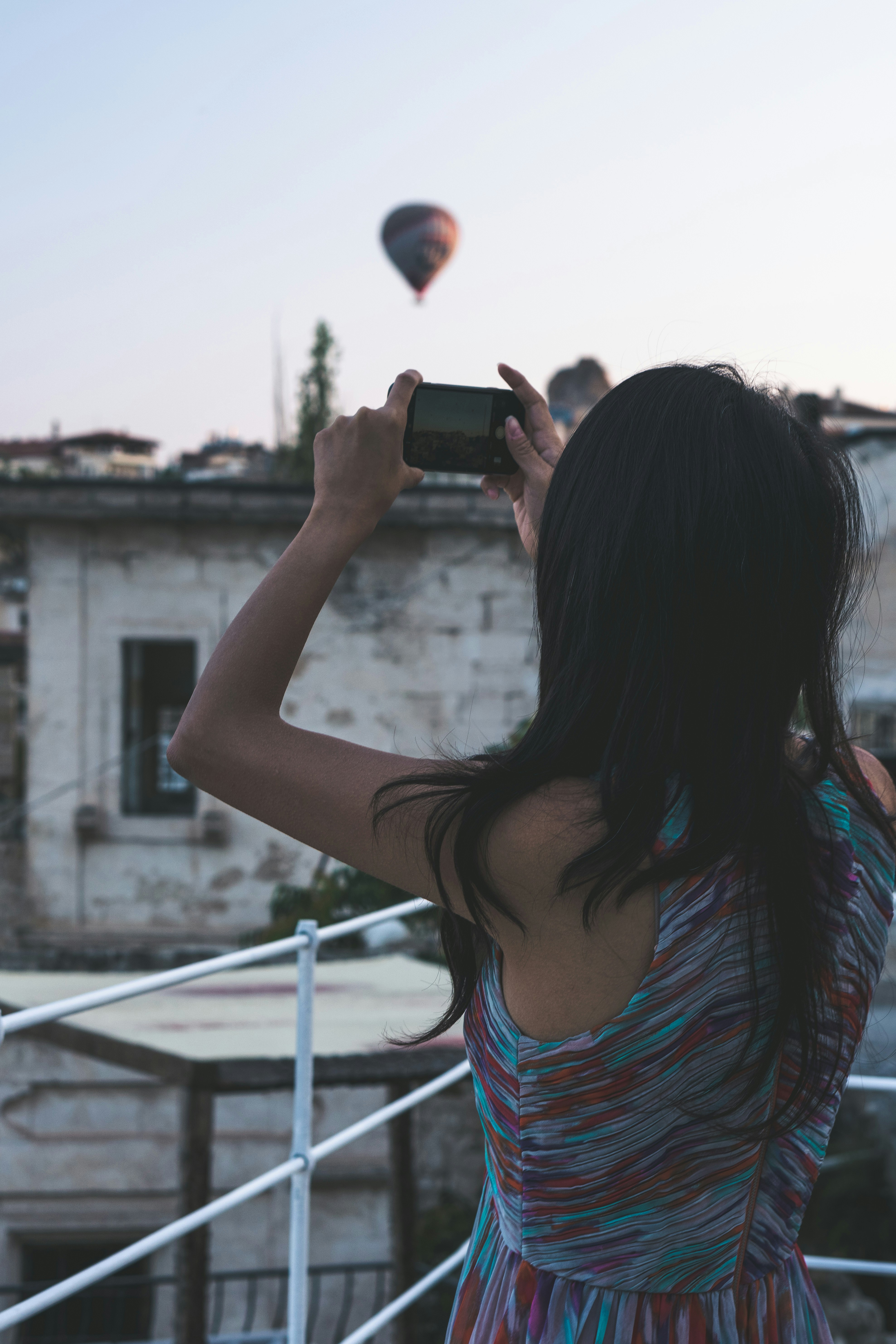 熱気球に立って写真を撮る女性