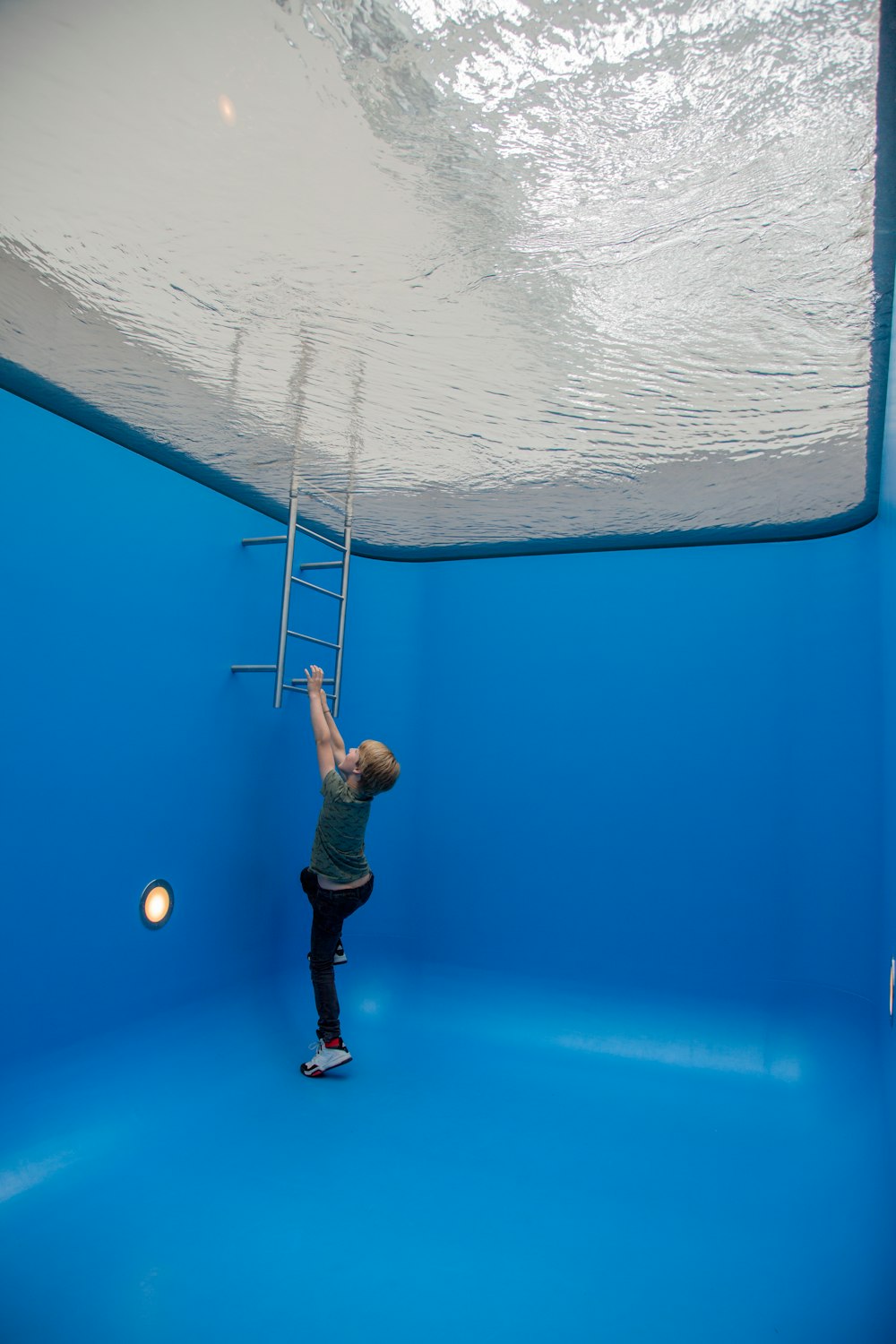 boy about to climb from swimming pool