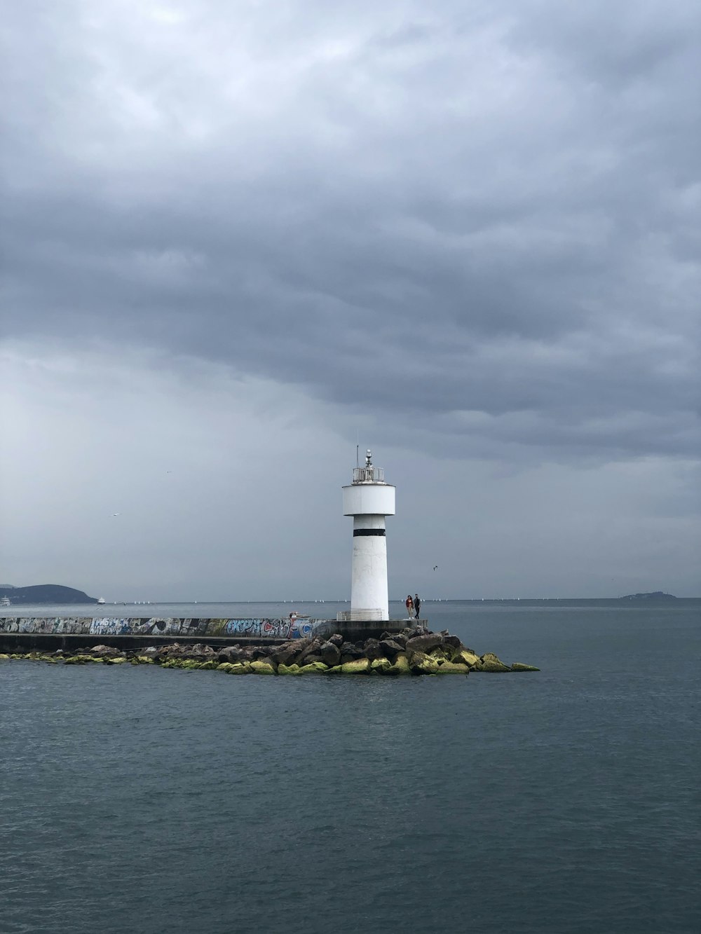 white lighthouse near shore during daytime