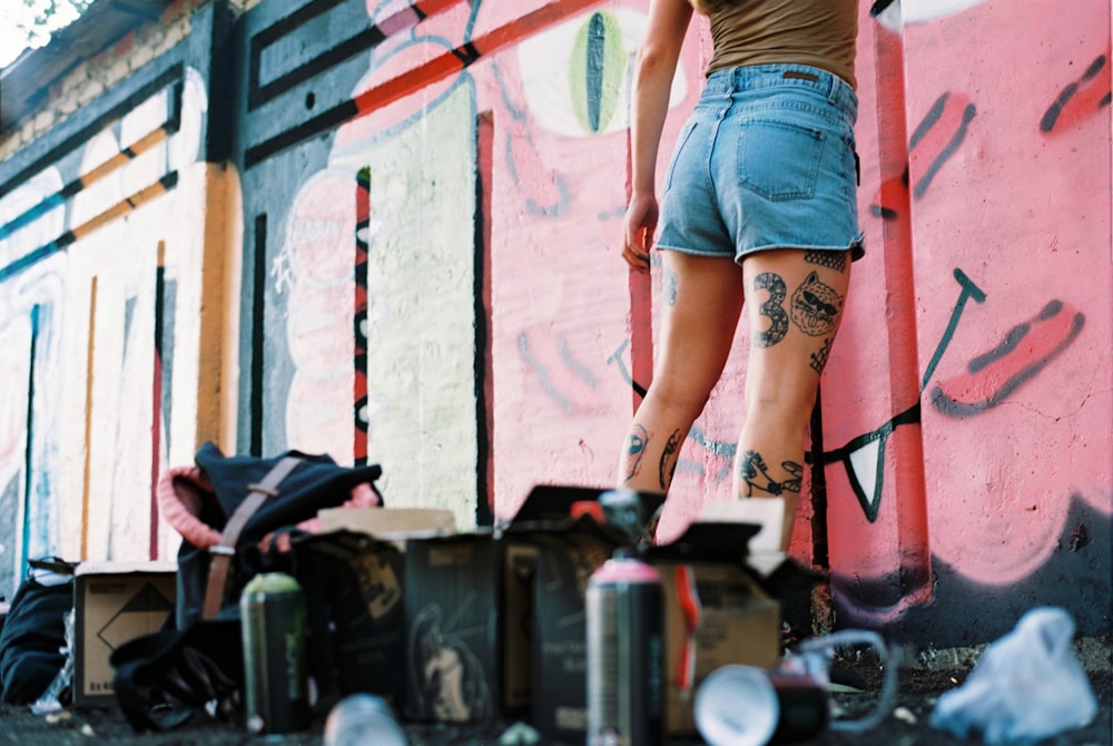 woman in blue denim short shorts painting graffiti