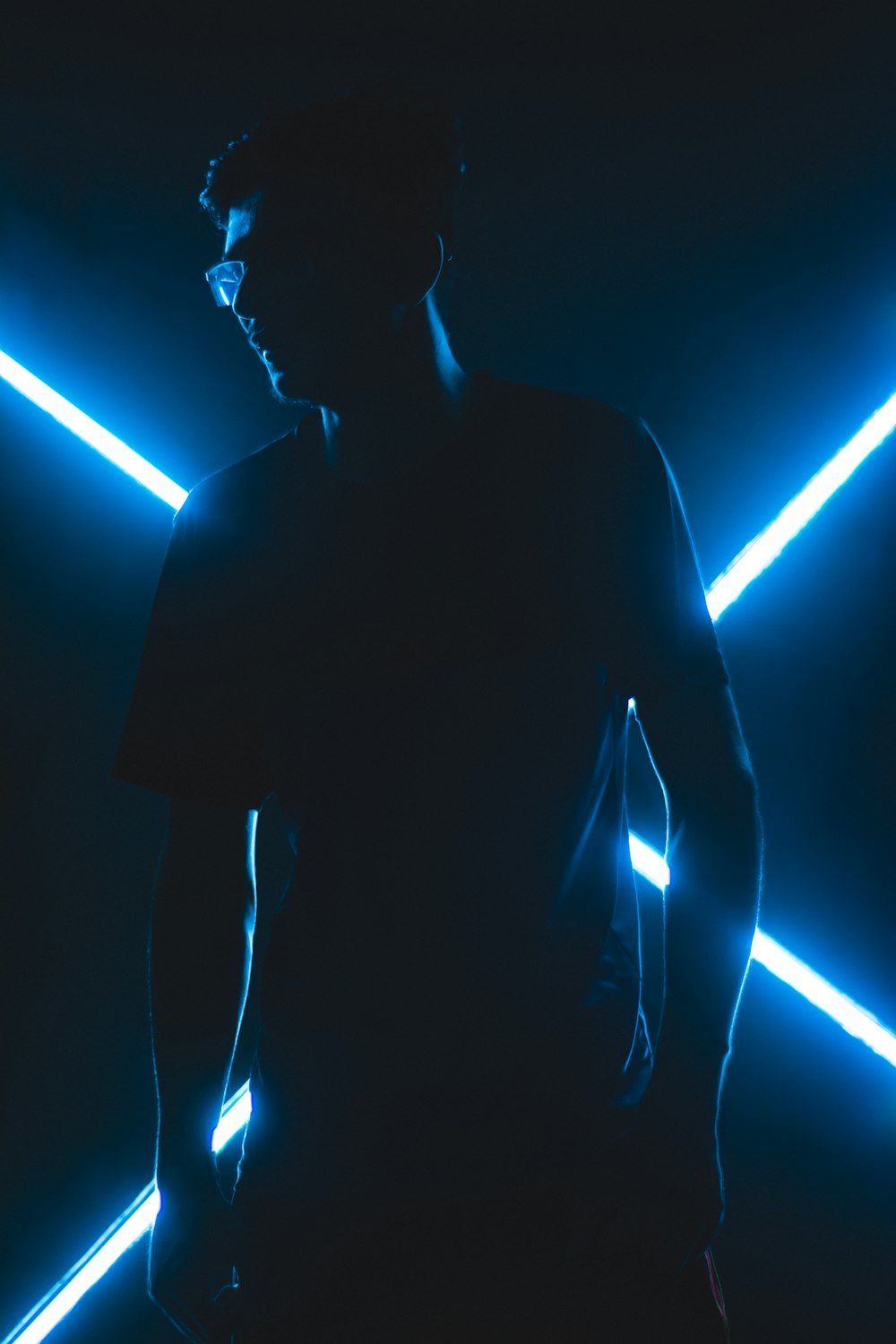 a man standing in a dark room with neon lights
