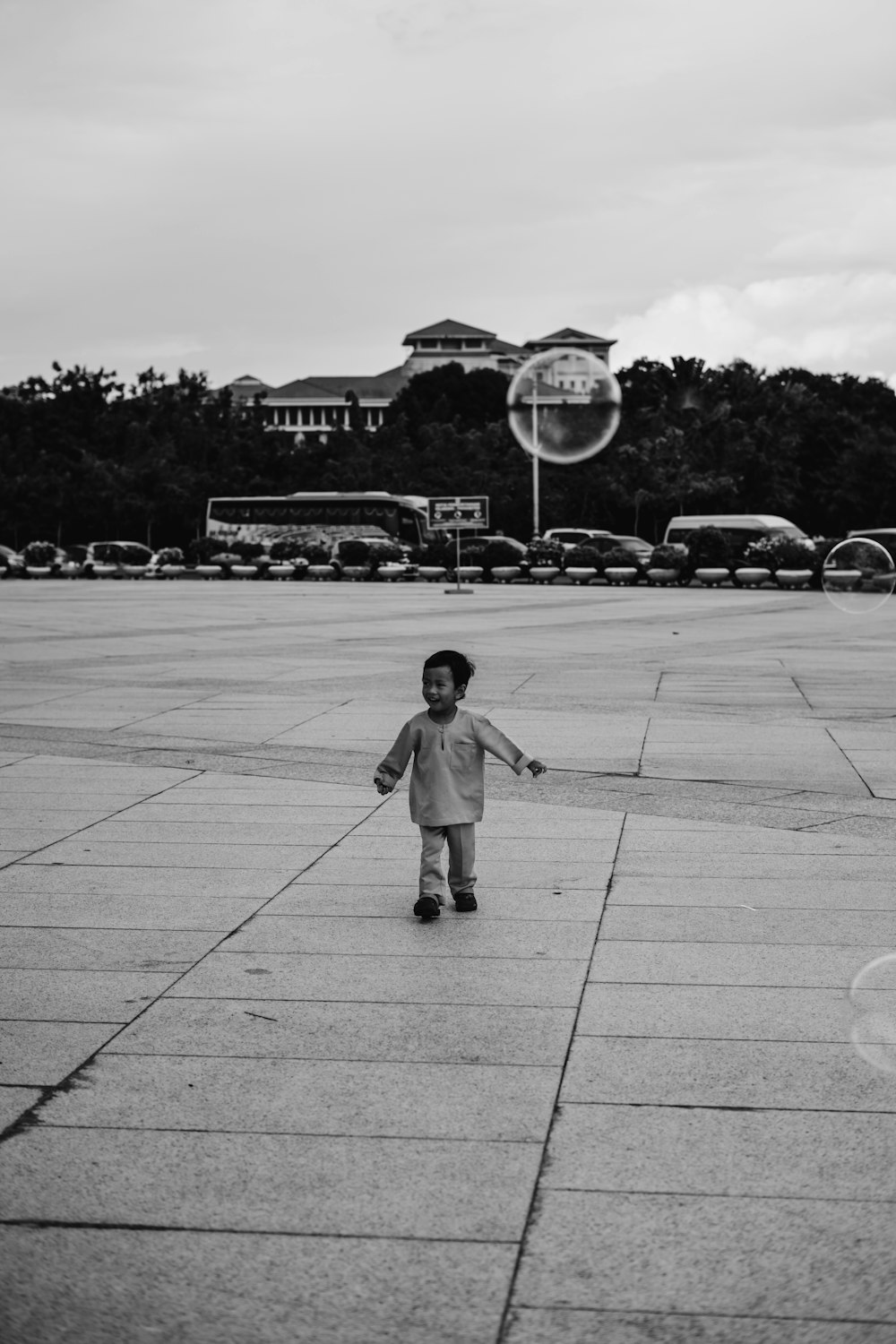 grayscale photo of boy walking in open field