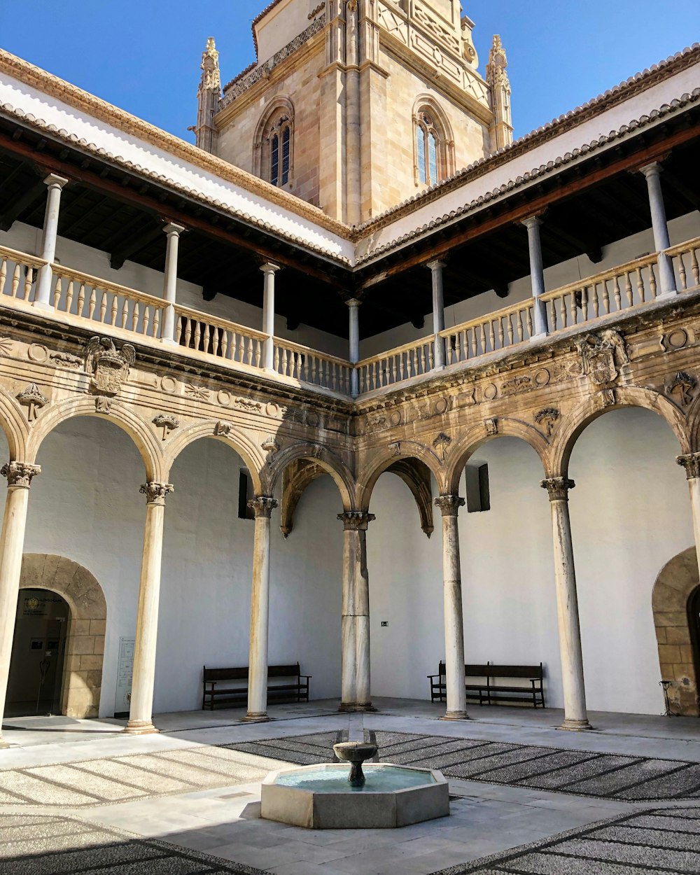 white and yellow building with mini water fountain