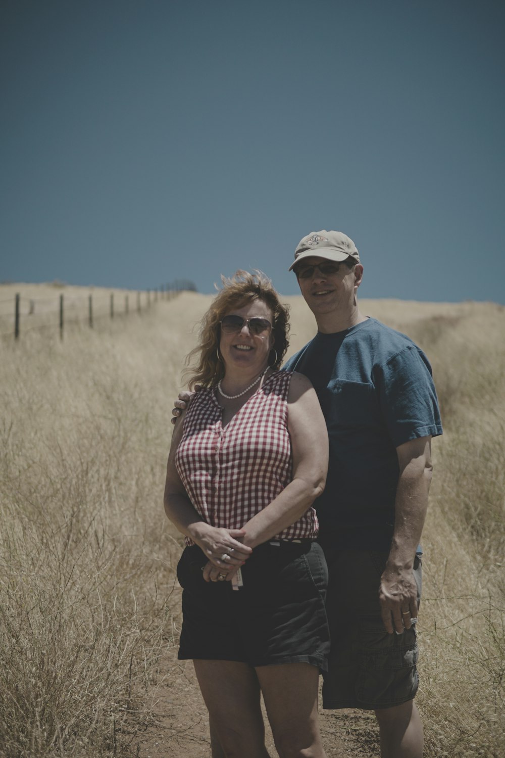 갈색 잔디 트레일에 서 있는 남자와 여자 커플