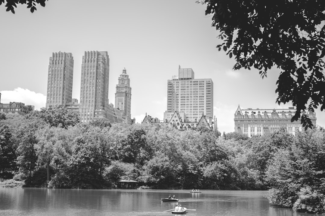 grayscale photography city with high-rise buildings viewing lake