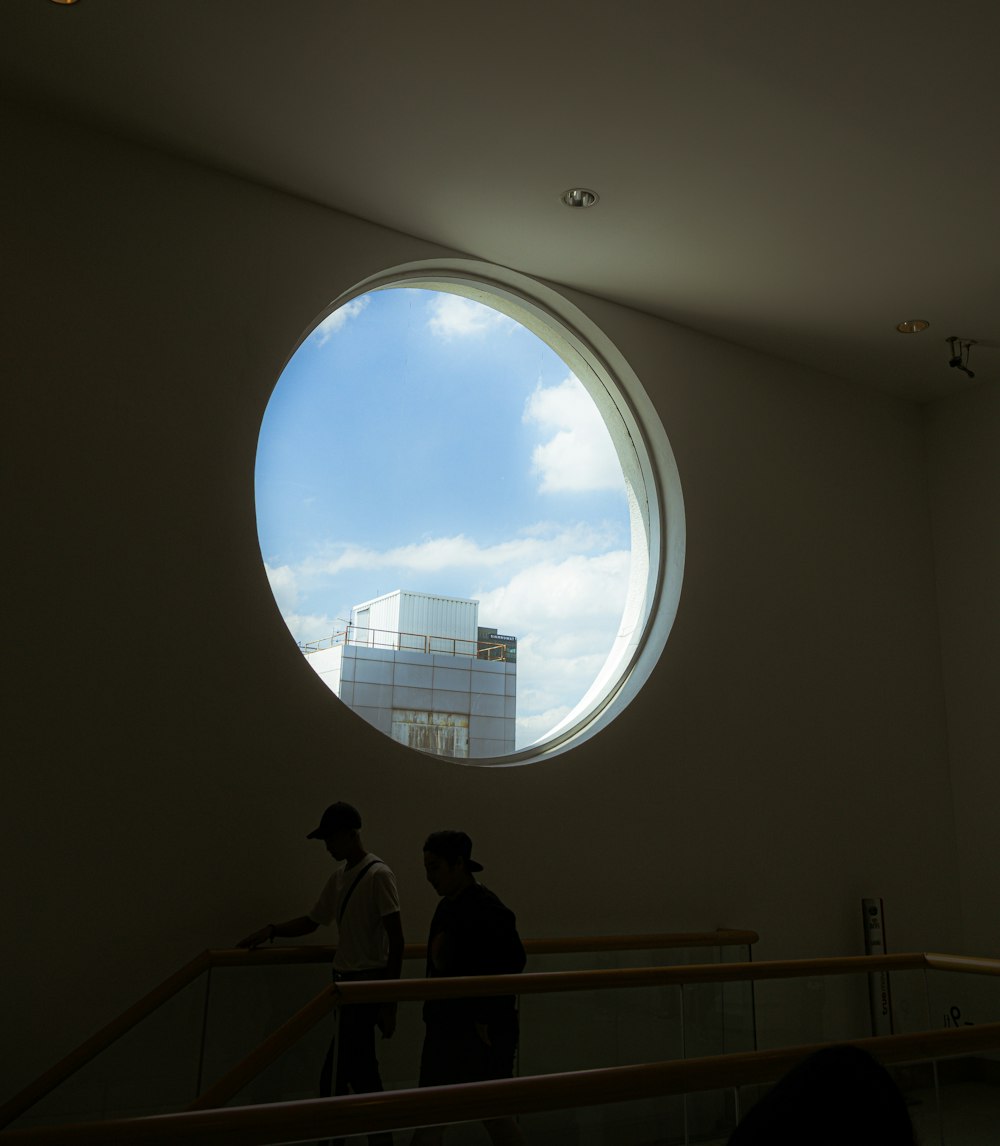 two people standing in front of a round window