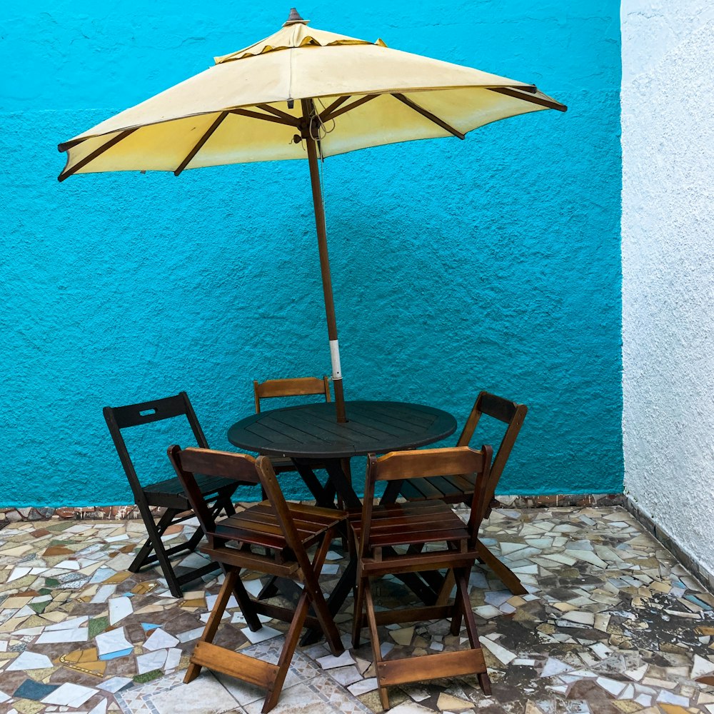 brown and black outdoor dining table with umbrella