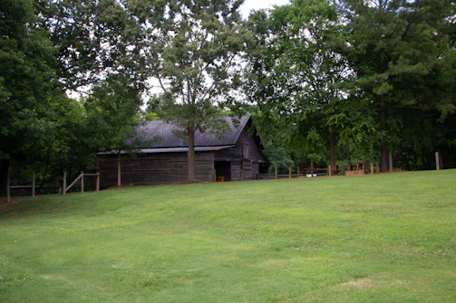 A cozy farmhouse venue surrounded by lush greenery, ready for a family function.