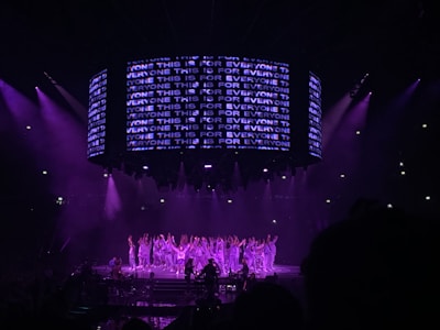performers on a stage with violet lights