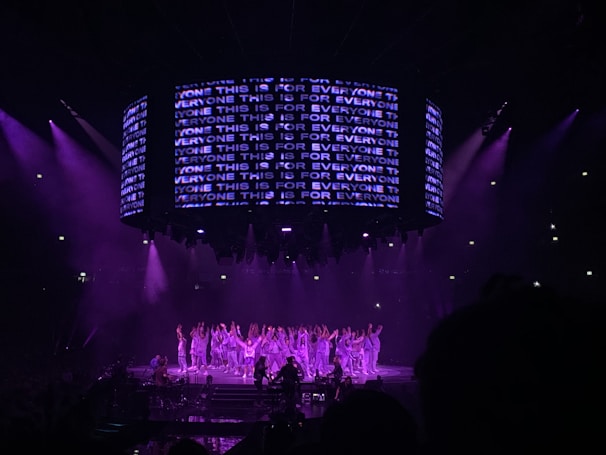 performers on a stage with violet lights