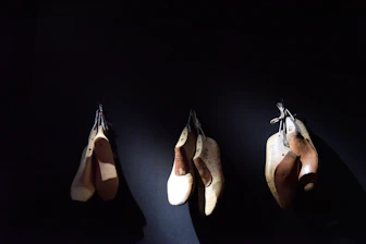 Custom-made foot orthotics displayed on a wooden table with clinic background