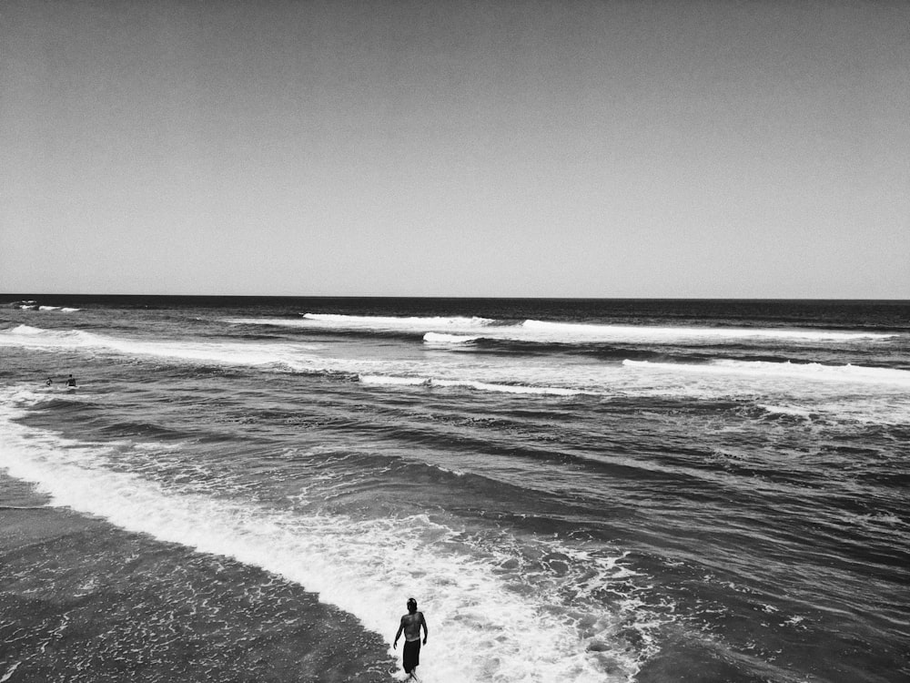 grayscale photo of a man at a beach
