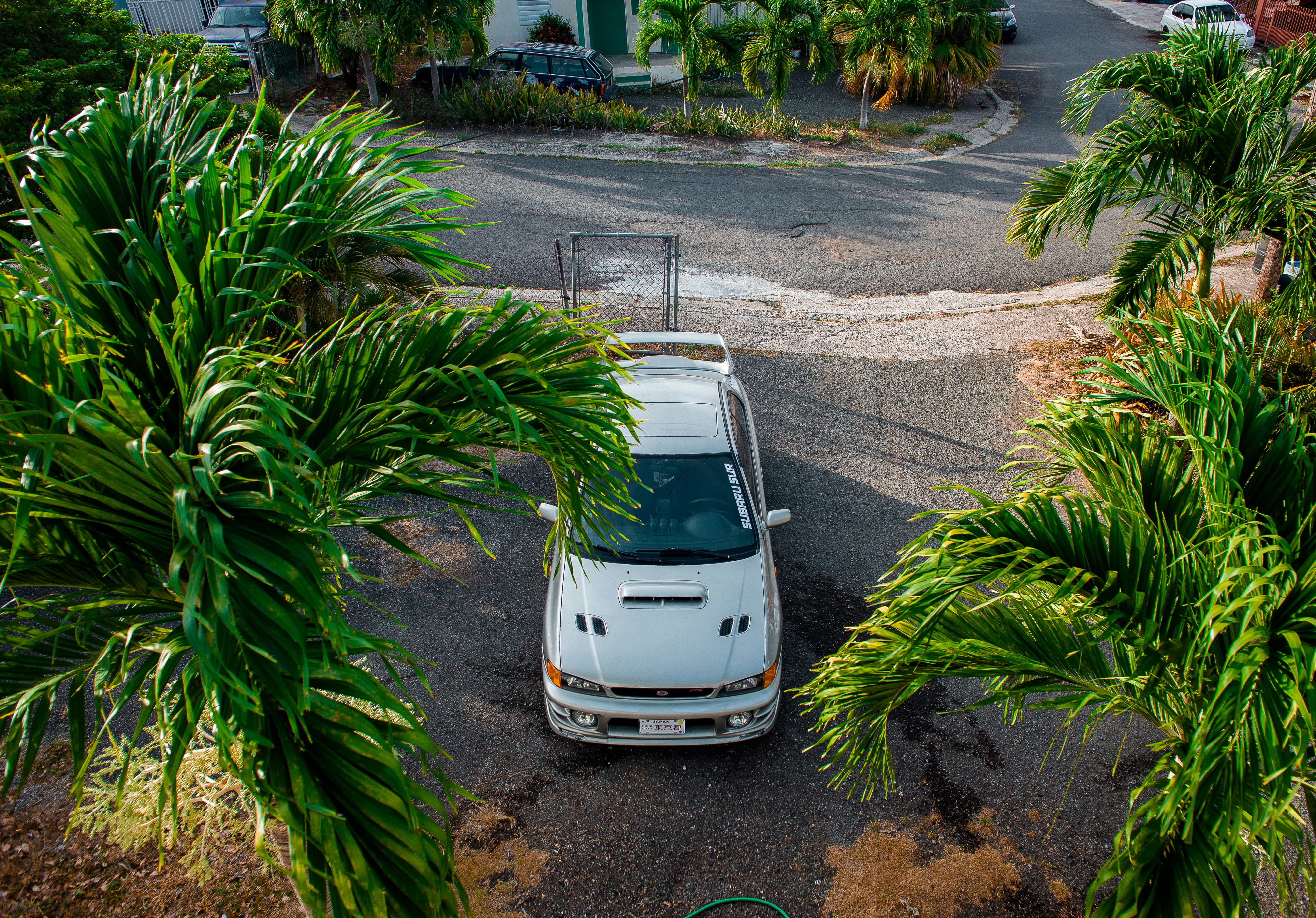 Small electric car parked in a tight urban curbside parking space
