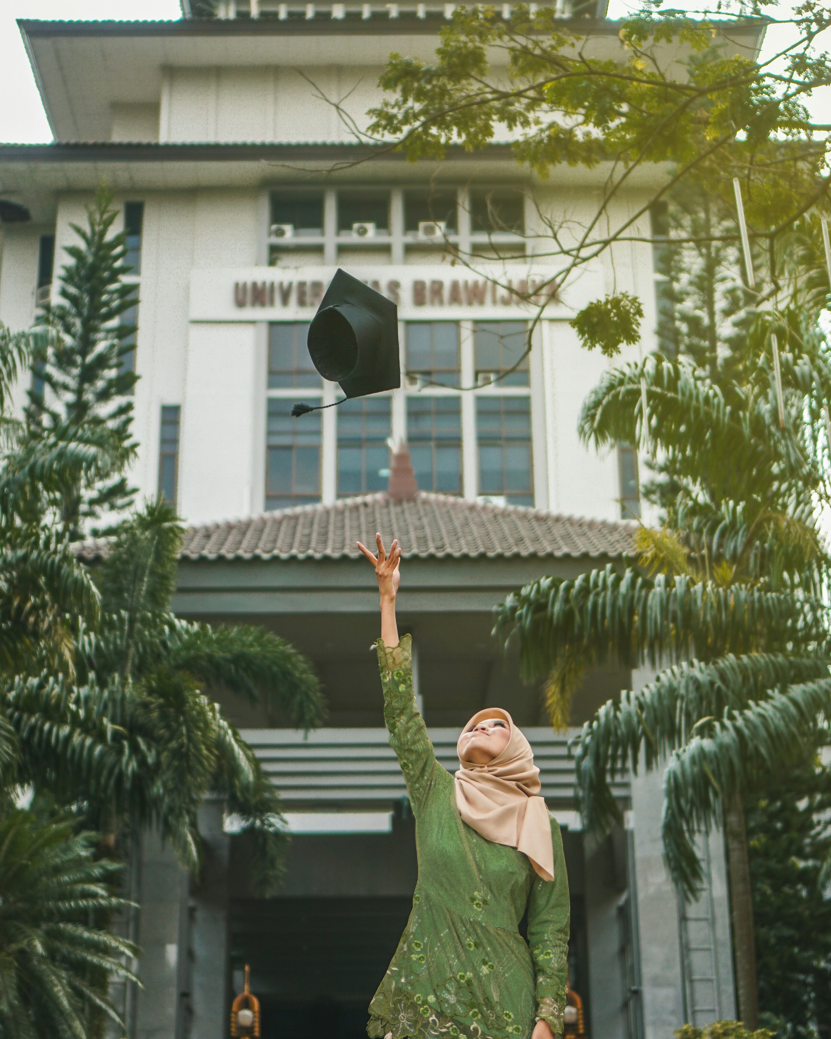 woman throwing mortar board during daytime