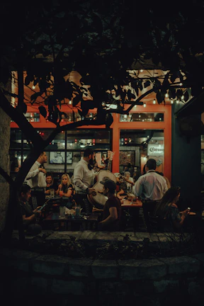 Cheerful group enjoying traditional Mexican meal in a warm, lively restaurant setting.