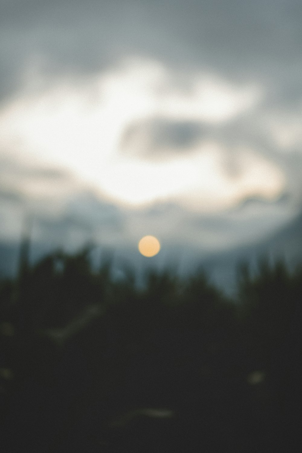 a blurry photo of the sun through the clouds