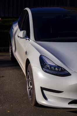 A sleek modern car parked under soft natural light, highlighting its shiny surface.