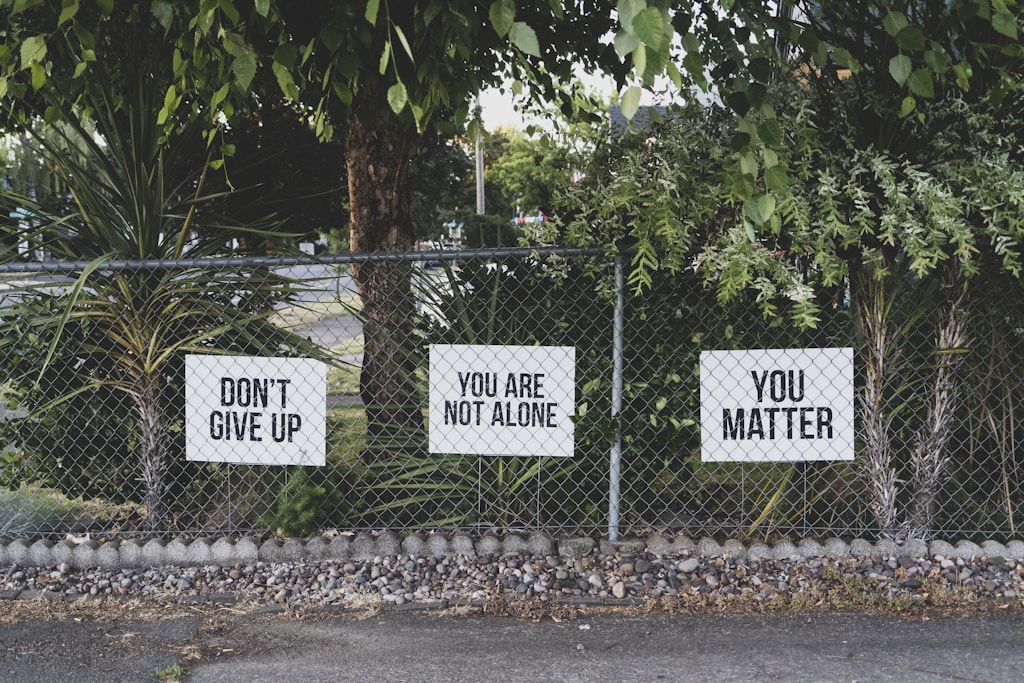 HR Trends: Motivational signs on a chain link fence.