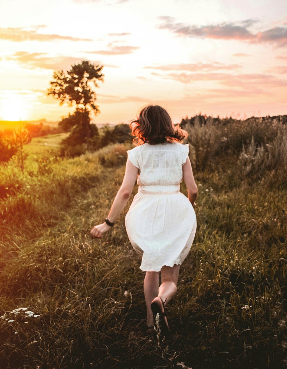 woman walking on grassy hill