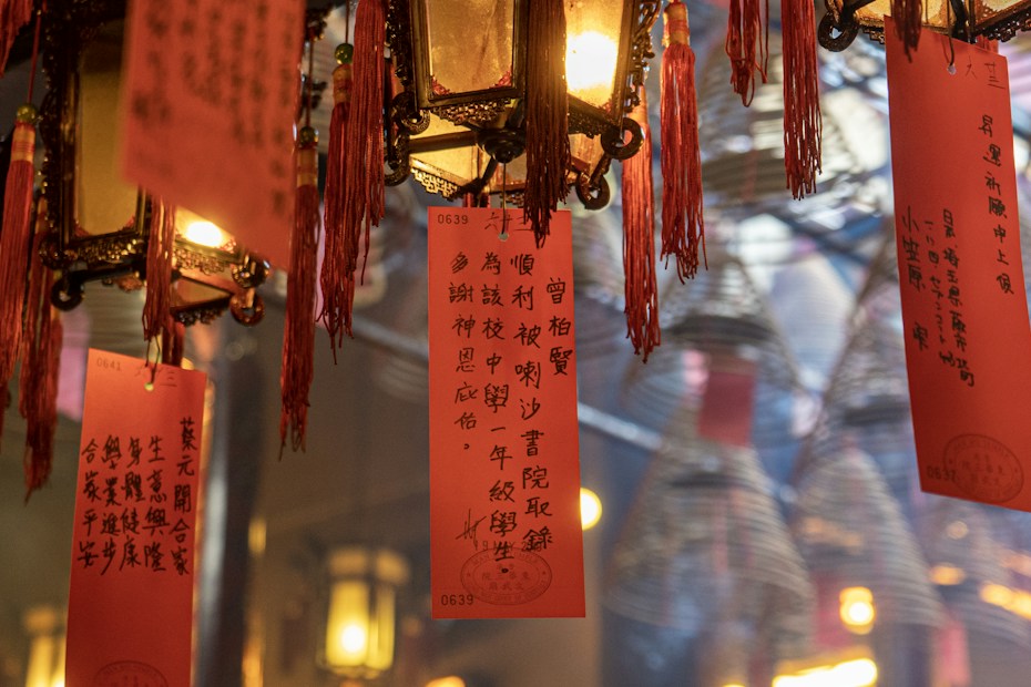 Hanging Chinese lanterns adorned with red tassels and ornamental scripts are visible, creating a warm and culturally rich atmosphere. The intricate design and soft lighting give a sense of tradition and ceremony.