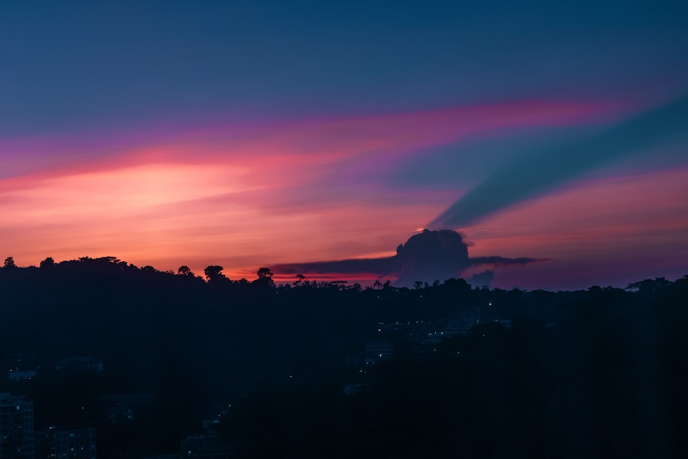 a sunset view of a city from a hill